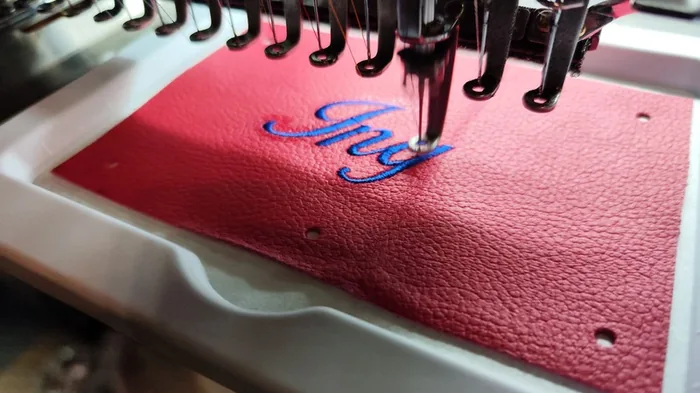 Blaue Schriftstickerei auf rotem Leder