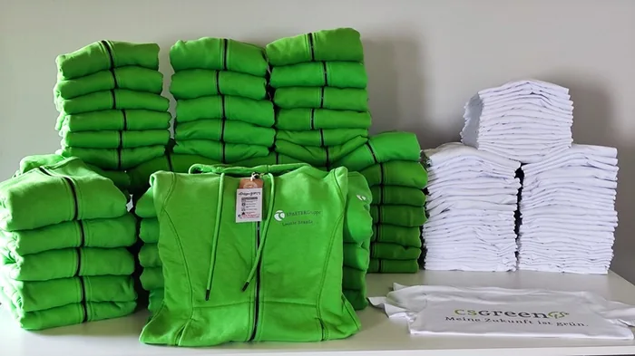 Gestapelte grüne Hoodies und weiße T-Shirts